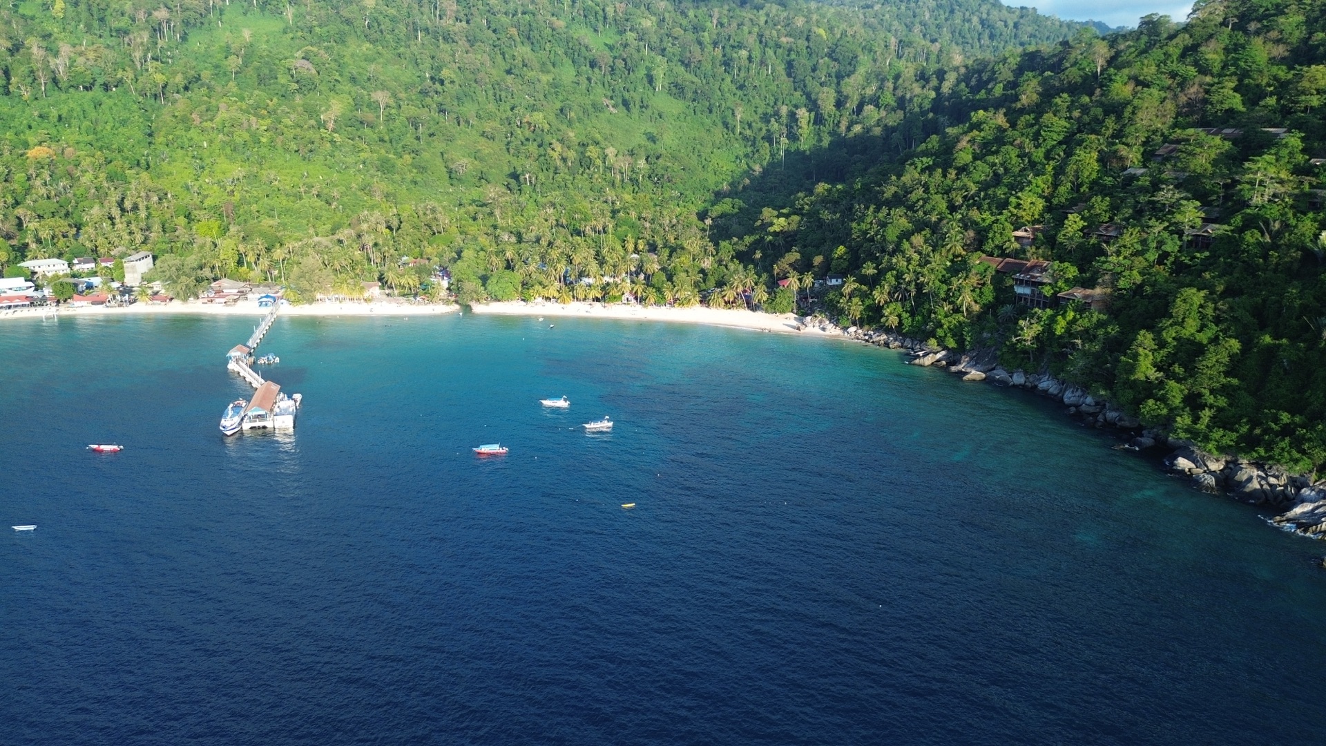 Drone view of Salang jetty, ferries and the southern cove of Salang Bay on Tioman Island